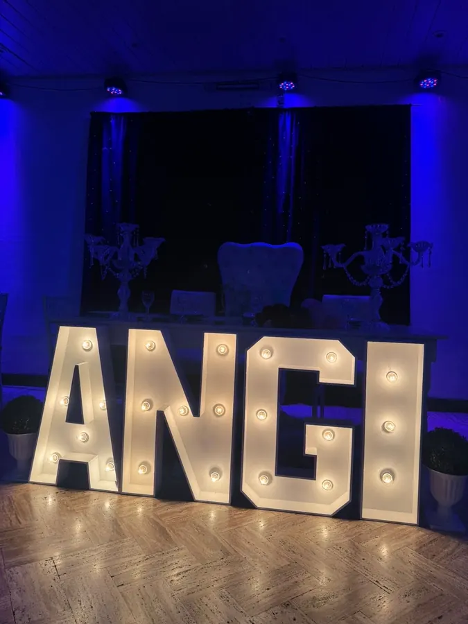 Letras ANGI iluminadas en una celebración