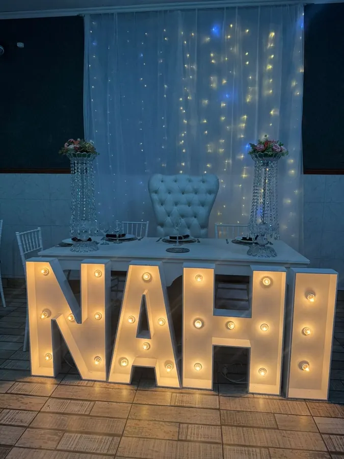 Letras NAHI iluminadas frente a una mesa principal