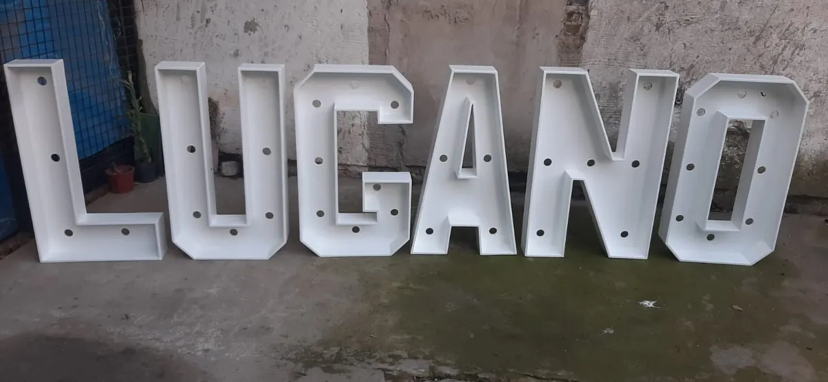 Letras LUGANO pintadas de blanco
